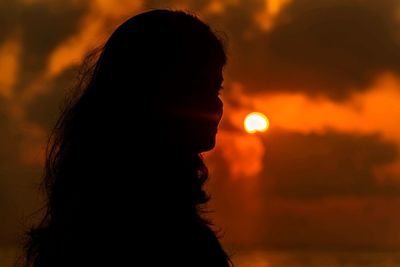Close-up portrait of silhouette woman against sky during sunset