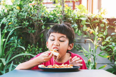 Portrait of woman eating food in restaurant