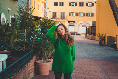 Woman standing by building in city