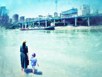 Rear view of people on bridge over river