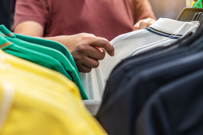 Midsection of man holding yellow dress