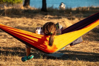 Rear view of woman lying on hammock at playground