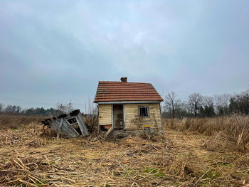 Abandoned house on field against sky