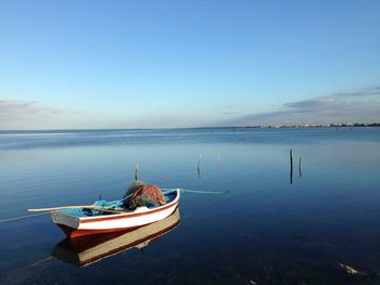 Boat moored on sea against clear sky