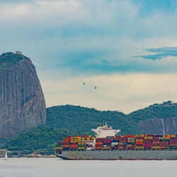 Photo of sugarloaf mountain with a cargo ship passing in front of it in guanabara bay