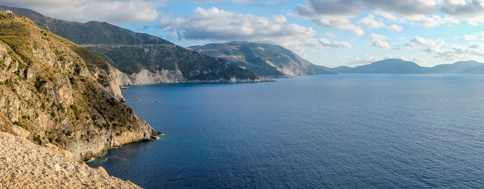 Scenic view of sea and mountains against sky