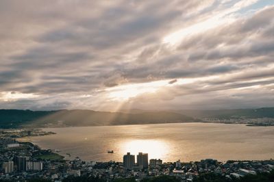 High angle view of cityscape by sea against sky