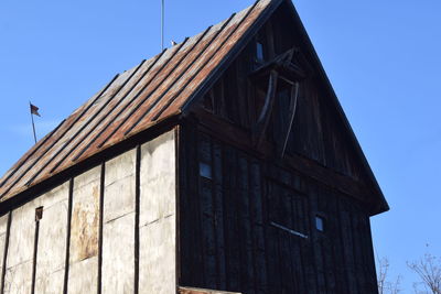 Low angle view of old building against clear blue sky