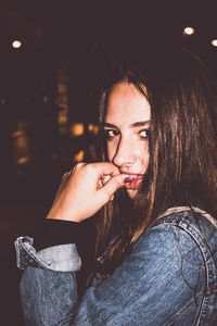 Close-up of young woman smoking at night