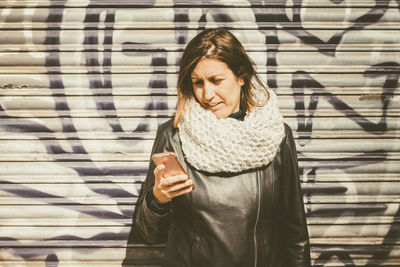 Young woman using phone while standing outdoors