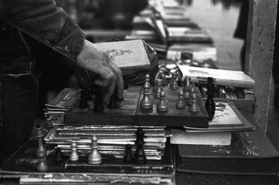 Cropped hand of man playing chess outdoors