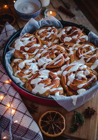 Homemade cinnamon rolls with cream cheese icing, on wooden background