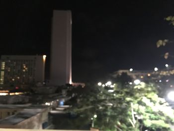 Illuminated buildings in city against sky at night