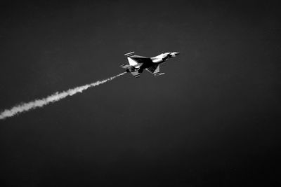 Low angle view of airplane flying against sky