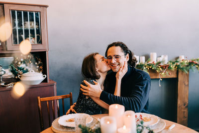 Young man and woman romantic couple couple hug at the dinner room christmas