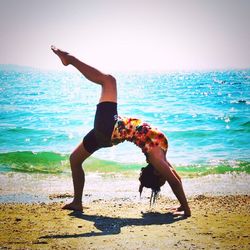 High angle view of woman jumping on beach