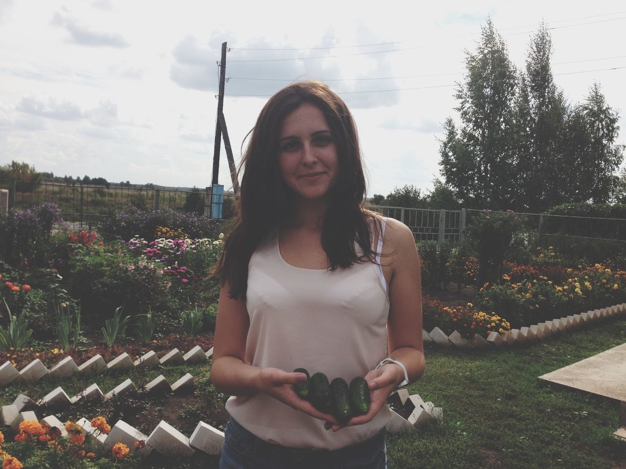 young adult, young women, person, lifestyles, looking at camera, portrait, casual clothing, front view, leisure activity, smiling, standing, long hair, flower, waist up, tree, three quarter length