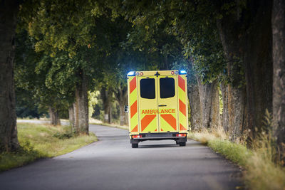 Yellow ambulance car of emergency medical service on country road. 