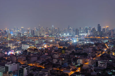 Illuminated cityscape against sky at night