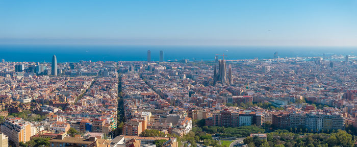 Aerial view of cityscape against clear blue sky