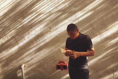 Portrait of young man against wall