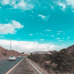 Cars on road against blue sky