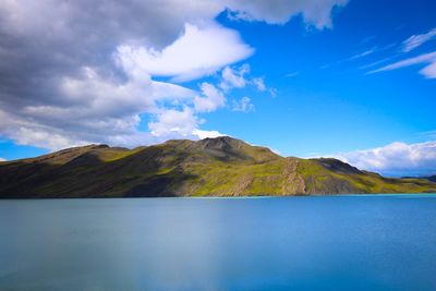 Scenic view of lake and mountains against blue sky