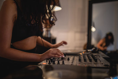 Fashionable young woman playing music at home