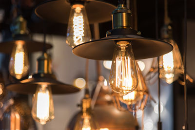 Close-up of illuminated pendant lights hanging in restaurant