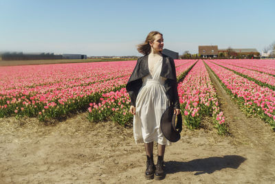 Full length of woman standing on tulip field