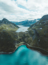 Scenic view of lake by mountains against sky