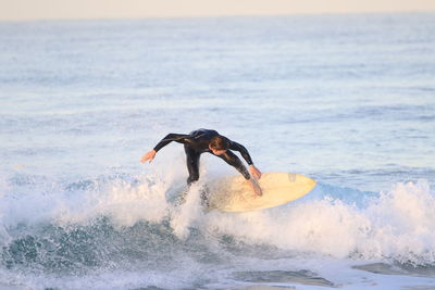 Man jumping in sea against sky