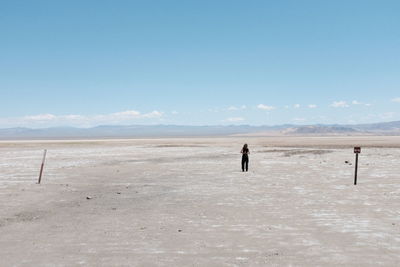 Full length of woman standing on landscape against sky