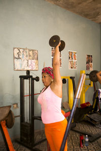 Full length of woman standing against wall