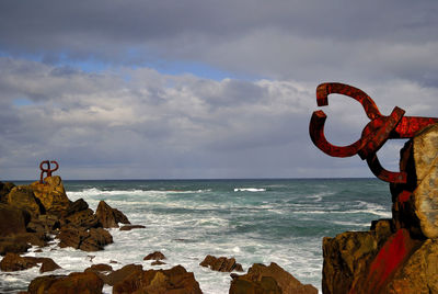 Scenic view of rocks on beach against sky