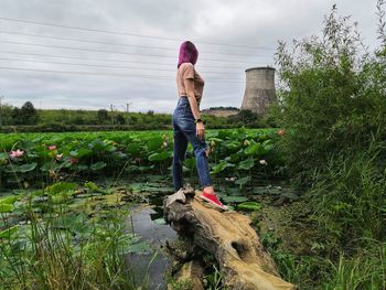 Full length of woman standing on field against sky