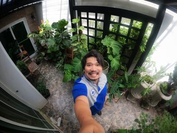 Portrait of smiling woman standing against plants