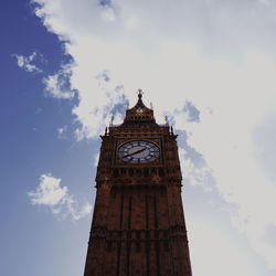 Low angle view of clock tower against cloudy sky