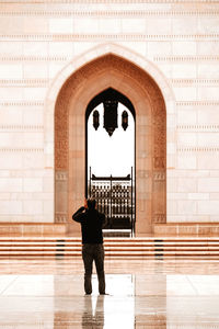 Rear view of silhouette man standing at entrance of building