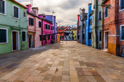Empty street amidst buildings against sky