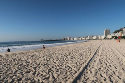 Scenic view of beach against clear blue sky