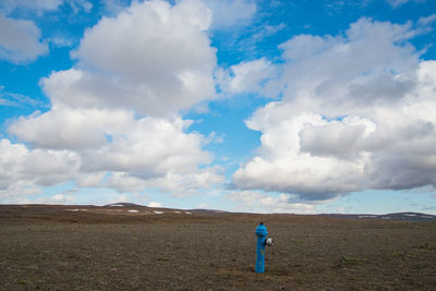 Man standing on field against sky
