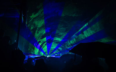 Silhouette people in illuminated nightclub at night