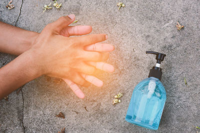 High angle view of hand holding bottle during rainy season