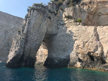 Rock formations by sea against sky