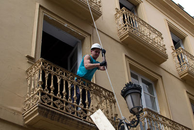 Low angle view of man standing against building
