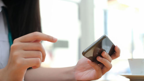 Midsection of man using mobile phone