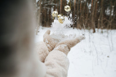 Midsection of woman catching christmas ornament and snow