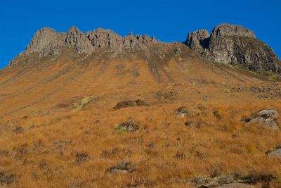 Scenic view of rocky mountains against clear blue sky