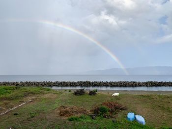 Scenic view of rainbow over sea against sky